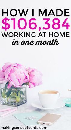 a cup of coffee sitting on top of a table next to a vase with pink flowers