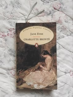 a book about jane eyre sitting on top of a white bed sheet with the title, charlotte bronte