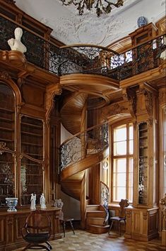 an ornately decorated living room with spiral staircase and bookshelf in the corner