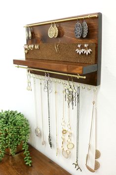 a wall mounted jewelry rack with several pairs of earrings hanging from it's sides