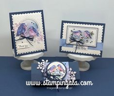 two cards with birds on them sitting on top of a table next to each other