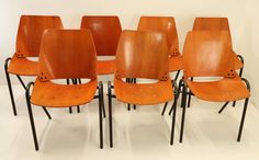 six orange chairs sitting side by side in a room