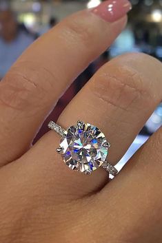 a woman's hand with a ring on her finger and a diamond in the middle