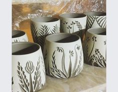 several white vases with black designs on them