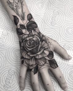 a person's hand with a rose tattoo on it