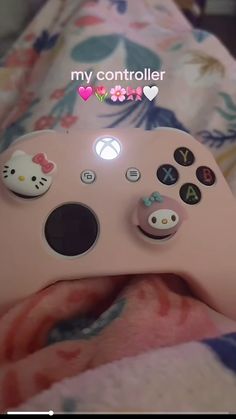 a close up of a pink controller with hello kitty stickers on the front and side