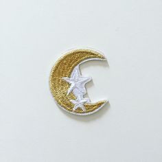 a white and gold crescent with a bird on it's side in the shape of a moon