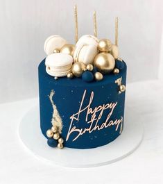 a birthday cake with gold and white decorations on it's blue frosted surface