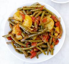 a white bowl filled with green beans and potatoes