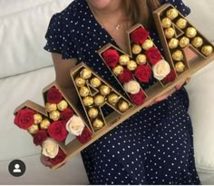 a woman is holding a box of chocolates with roses in the letters m and w