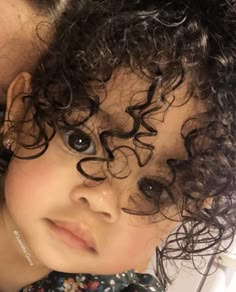 a close up of a child with curly hair