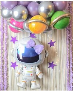 an astronaut balloon wall hanging from the ceiling with balloons in the air and stars around it