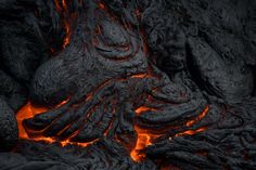 the lava is glowing red and orange as it moves through the dark, rocky ground