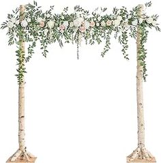 two tall trees with white flowers and greenery on each tree are arranged in the shape of an arch