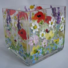 a glass vase with flowers painted on it