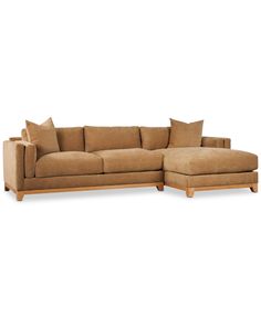 a large sectional couch with pillows on the top and bottom corner, in tan fabric