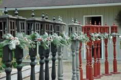 a row of red and gray wooden posts with christmas decorations on them