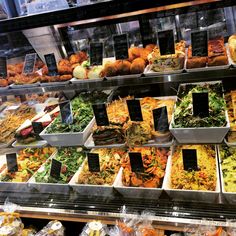 a display case filled with lots of different types of food in bins next to each other