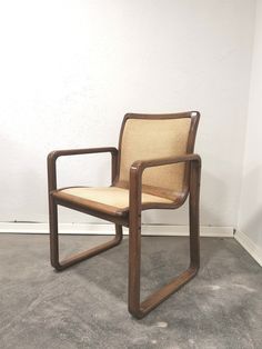 a wooden chair sitting on top of a carpeted floor next to a white wall