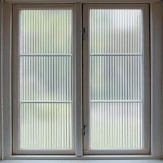 an open window with vertical blinds on the outside and inside windows that are closed to let in light