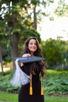 a woman in a black dress holding a frisbee and smiling at the camera