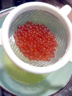 a white cup filled with red liquid on top of a saucer