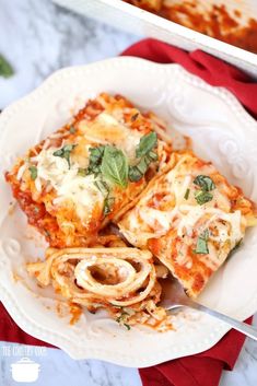 a white plate topped with lasagna covered in cheese