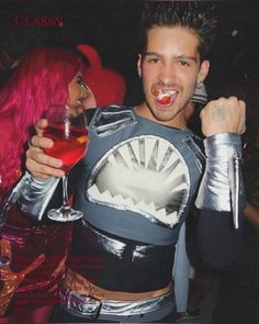 a man and woman dressed up as sharkgirls at a party with drinks in their hands