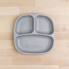 a gray plastic plate with two compartments on the bottom and one compartment in the middle