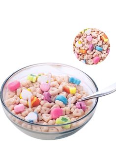 a bowl filled with cereal and marshmallows next to a spoon on a white background