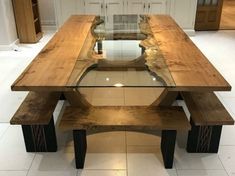 a wooden table with two benches in front of it on tile flooring and white walls