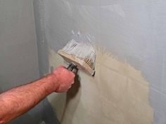 a man using a paint roller on the wall