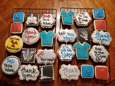 decorated cookies with thank you written on them are sitting on a cooling rack in front of a wooden table