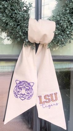 the front door is decorated with two purple and white tiger heads on burlocks