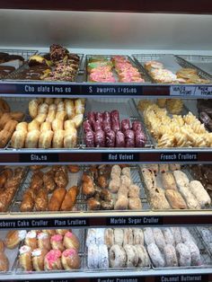 a display case filled with lots of different types of doughnuts and pastries