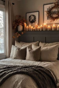 a bedroom with candles on the headboard and bed in front of a large window