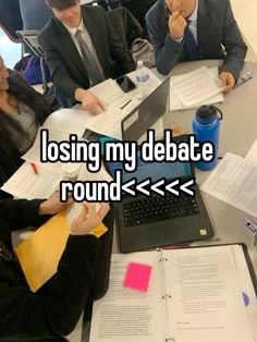 people sitting at a table with papers and laptops in front of them that says losing my debate round > > >