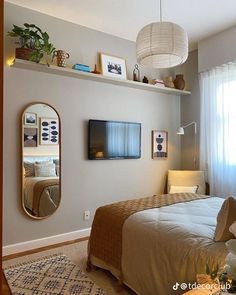 a bedroom with a bed, mirror and hanging lights on the wall next to it