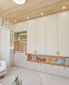 a baby's room with white furniture and green wallpapers on the walls