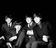 black and white photograph of four men in suits