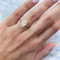 a woman's hand with a ring on it and a diamond in the middle