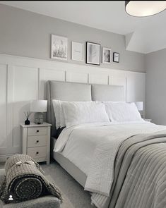 a bed with white sheets and pillows in a room