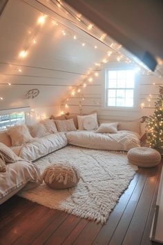 a living room filled with lots of white furniture and christmas lights on the wall above it