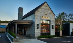 the outside of a restaurant with an awning on it's roof and windows