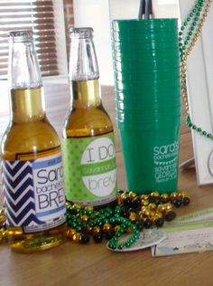 three beer bottles sitting on top of a wooden table next to a bag and chain