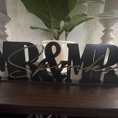 a wooden sign that says mr and mrs sits on a table next to a potted plant