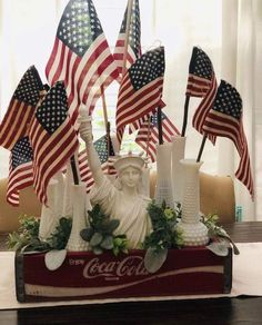 the statue of liberty is surrounded by many american flags and other patriotic decorations on a table