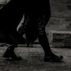 a man is walking down the street in black and white