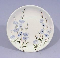 a white plate with blue flowers painted on it