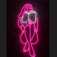 a neon sign with a woman reading a book in the shape of a rectangle